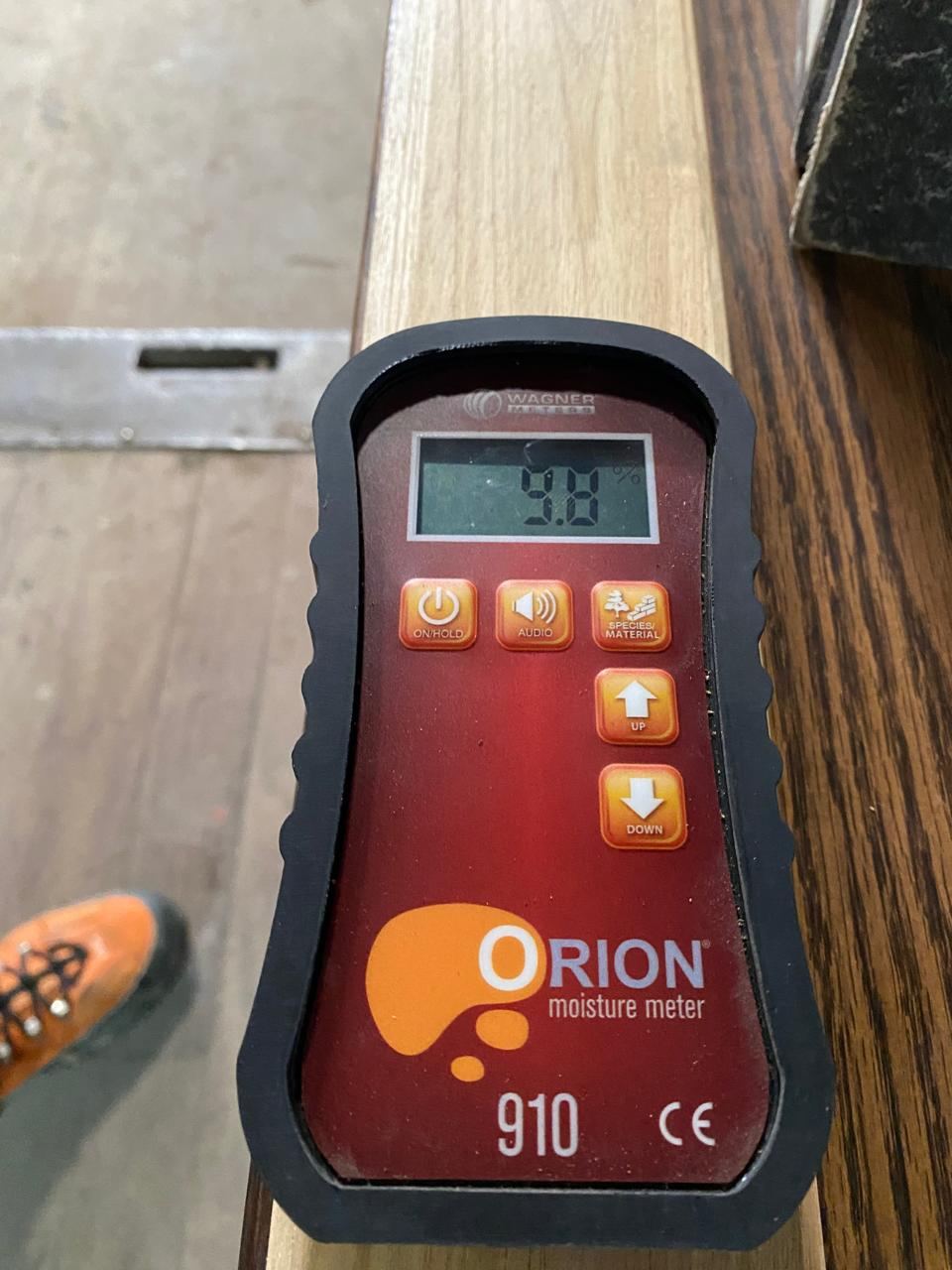 Moisture meter reading 9.8% on a kiln-dried teak board